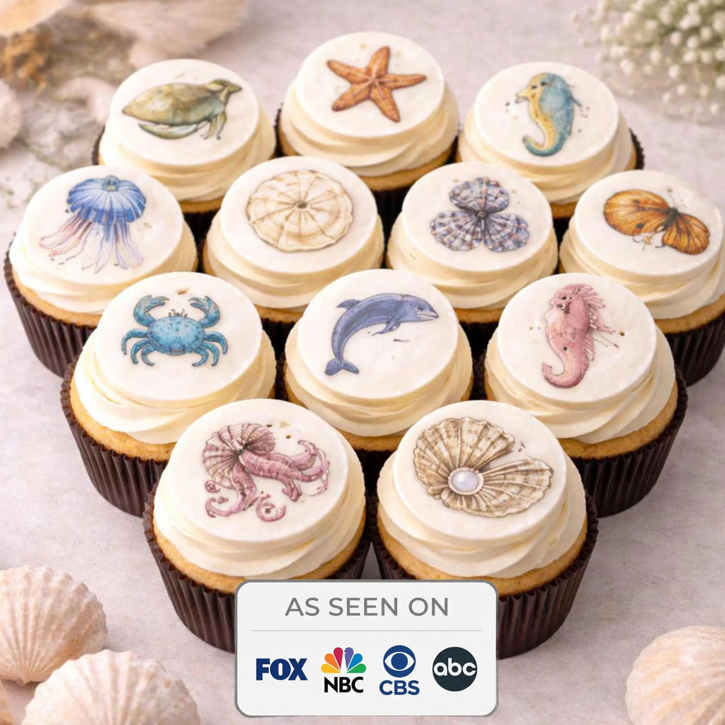 Set of 12 edible ocean-themed cupcake toppers featuring colorful sea creature designs by SugarPrints for decorating desserts.