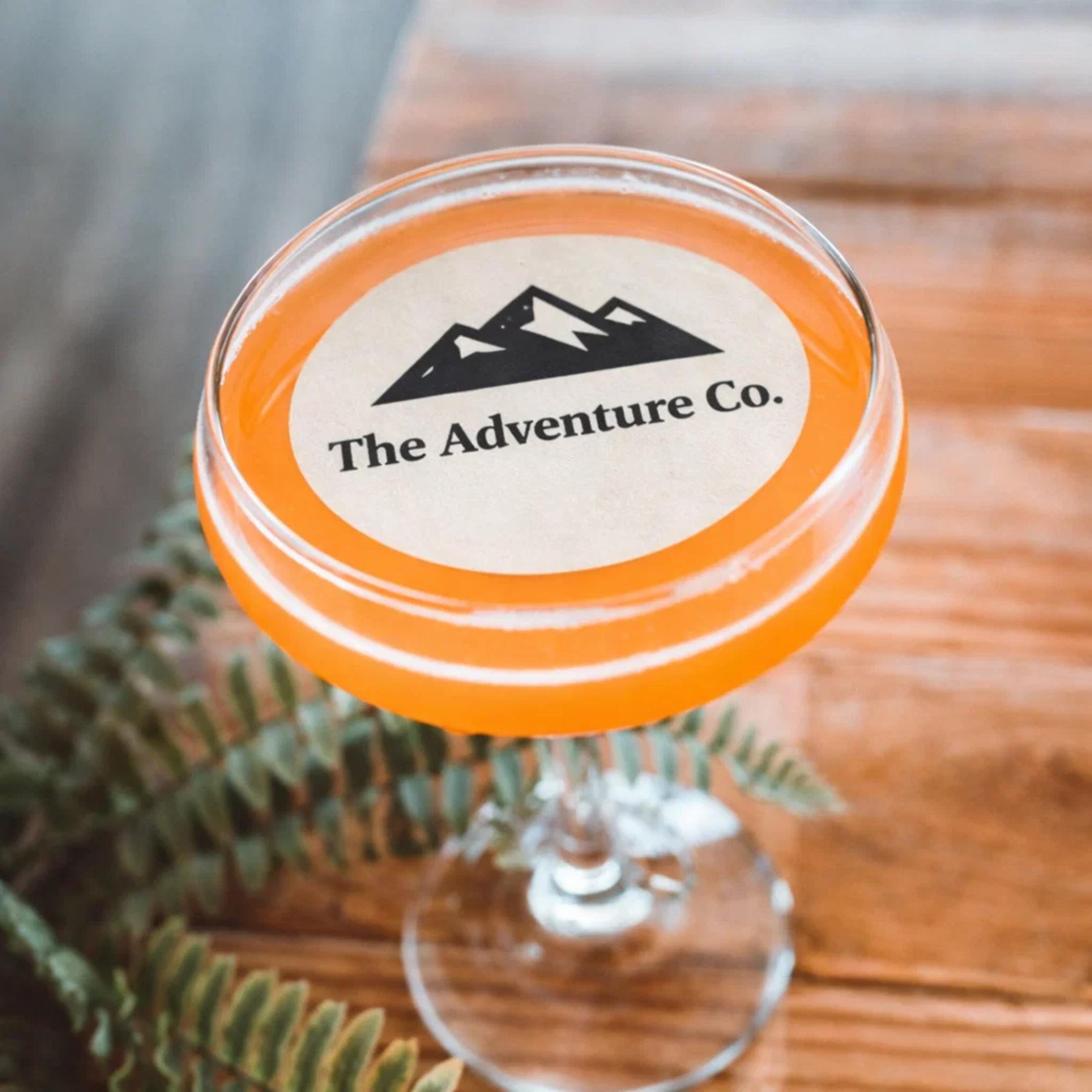 Edible wafer paper drink toppers with custom logos for corporate events, featuring colorful printed circles by SugarPrints by Alexis.